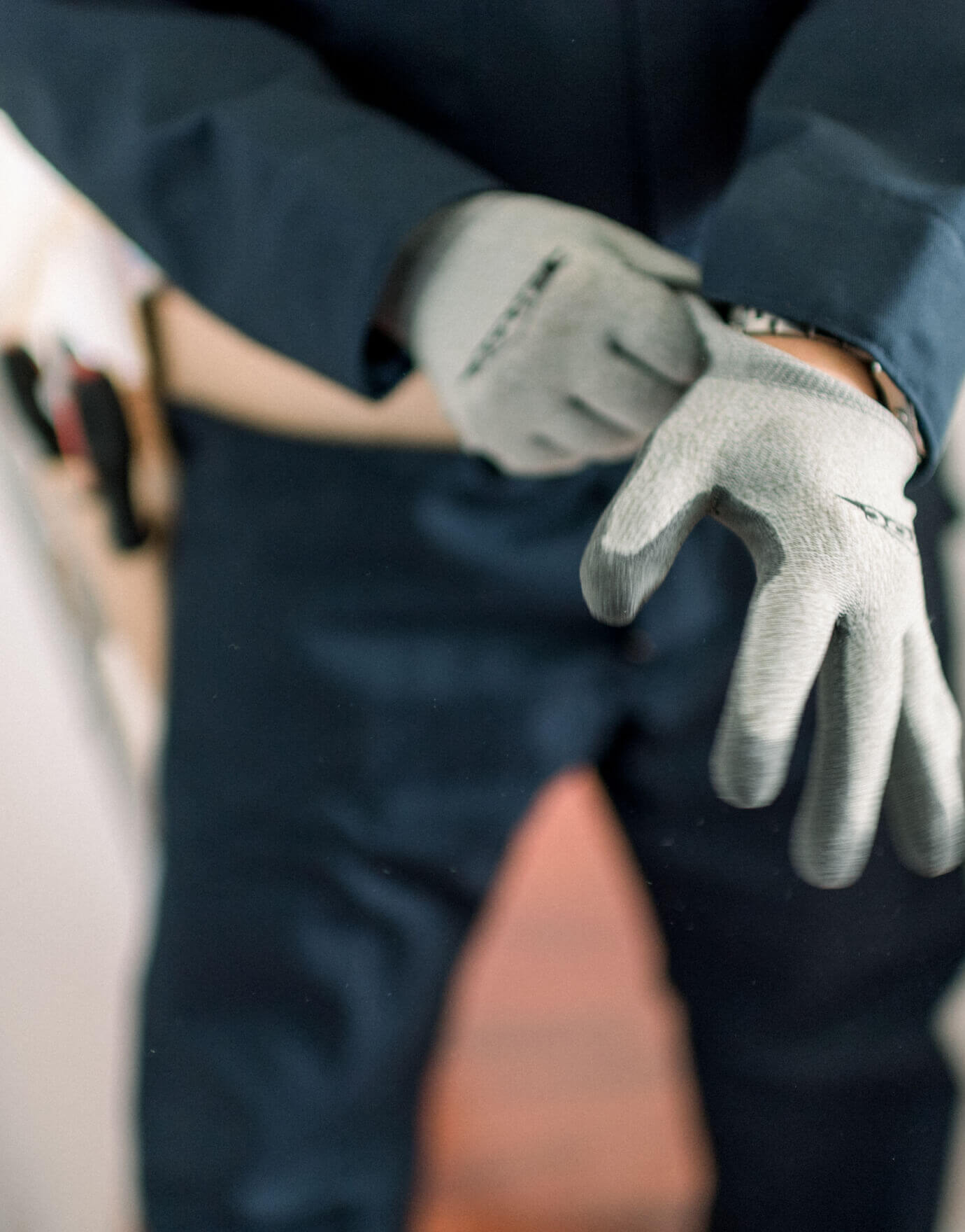 Foto de electricista poniéndose guantes de trabajo.